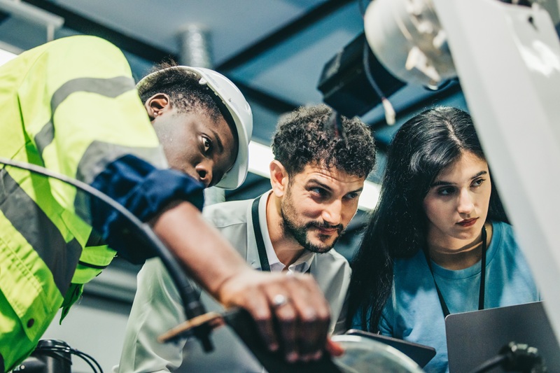 Robotic engineer and team oversee software, machine tool perform